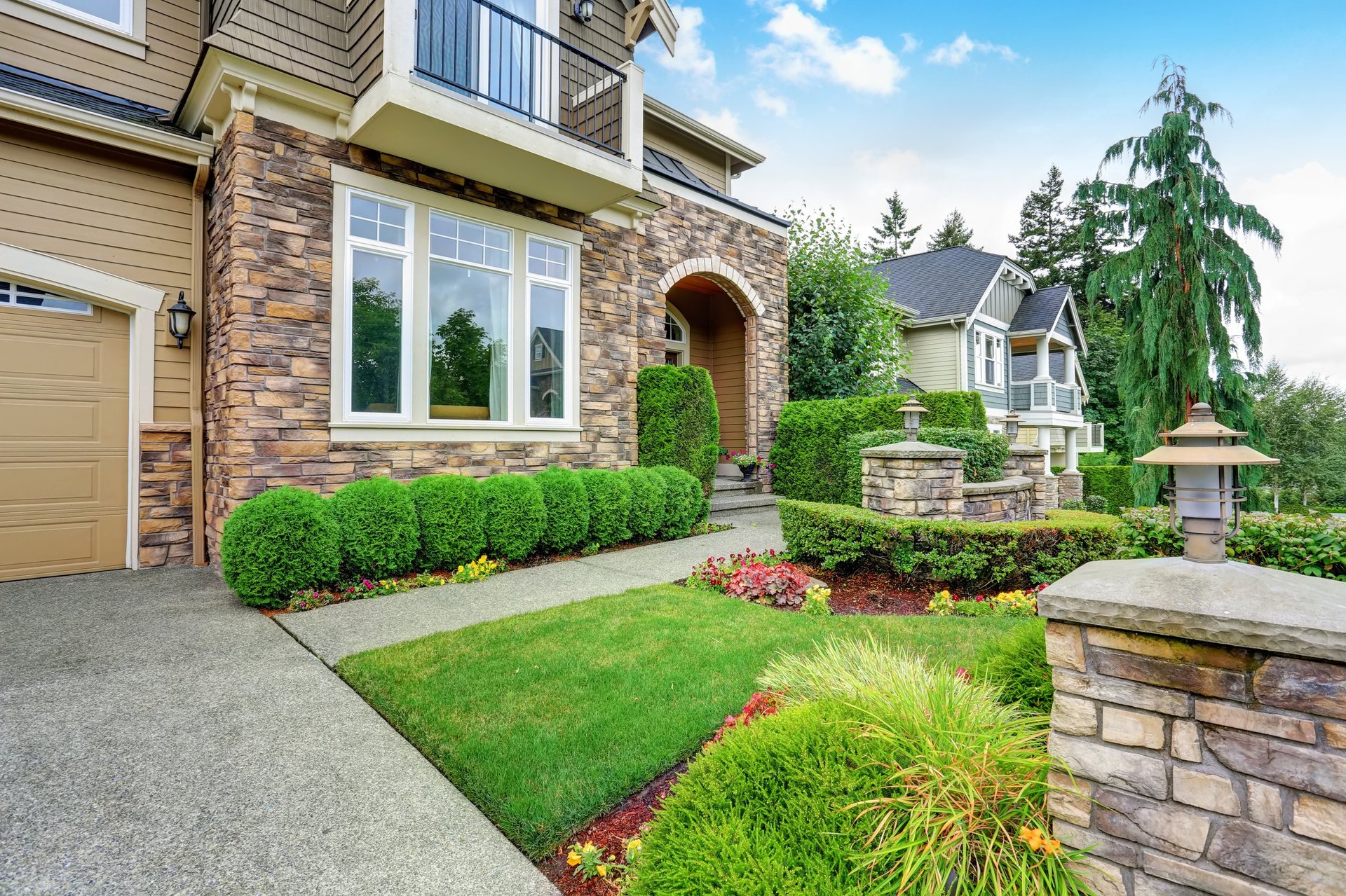 Beautiful curb appeal with perfectly trimmed hedges and elegant landscaping